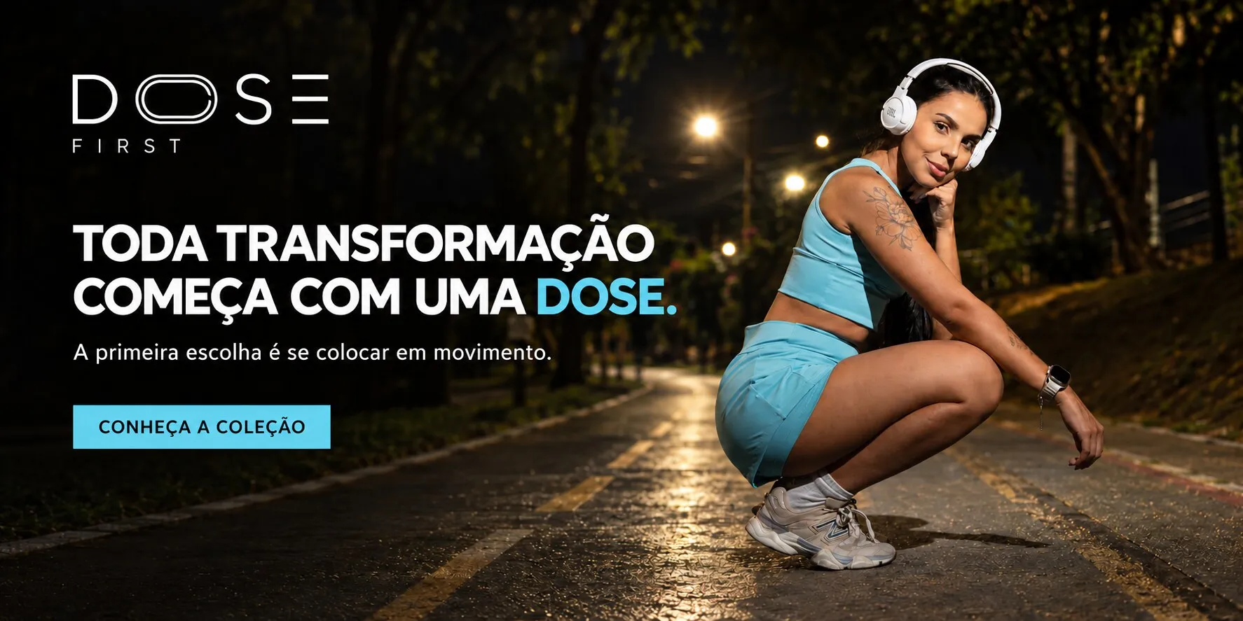 Dose First. Toda transformação começa com uma dose. A primeira escolha é se colocar em movimento. Modelo agachada numa pista à noite, com o Conjunto Run DOSE azul-claro e fones de ouvido. Conheça a coleção.